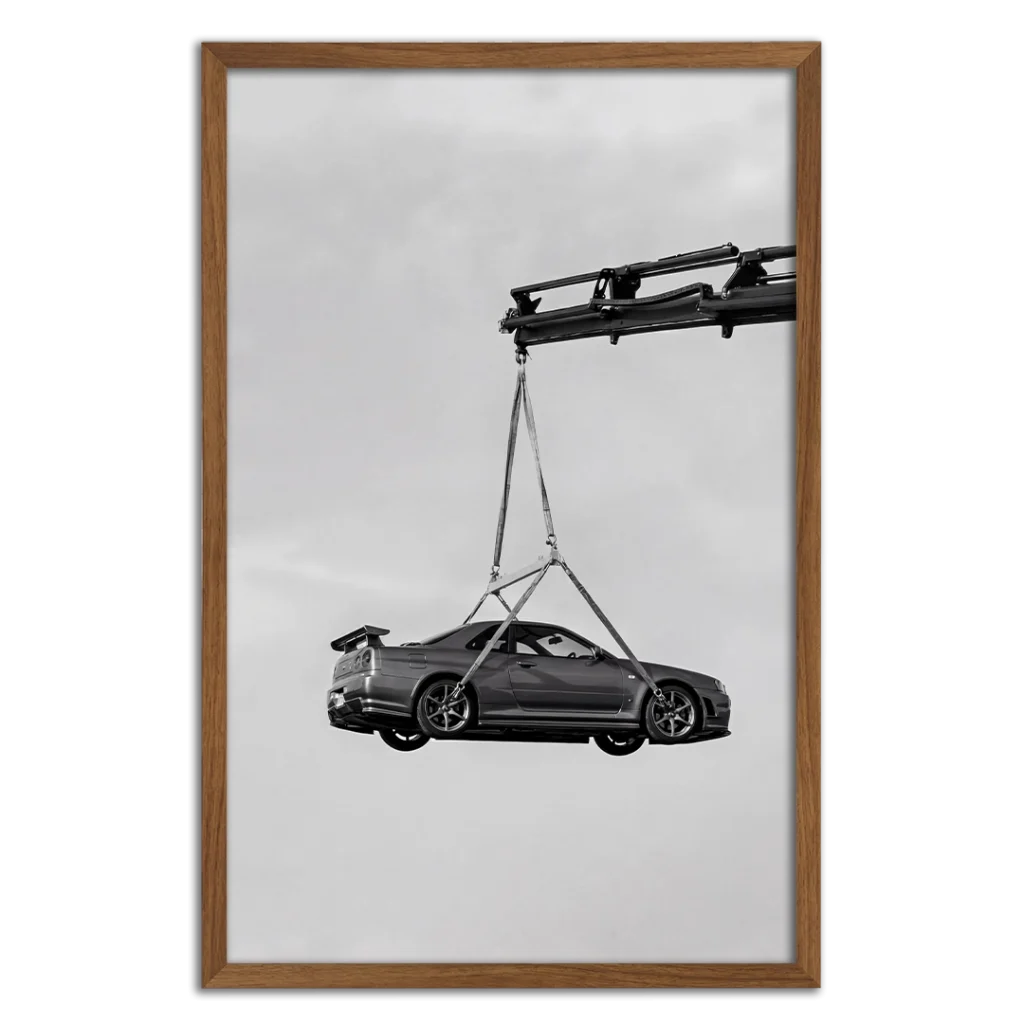 Framed photography print of an R34 GTR being lifted by a crane.