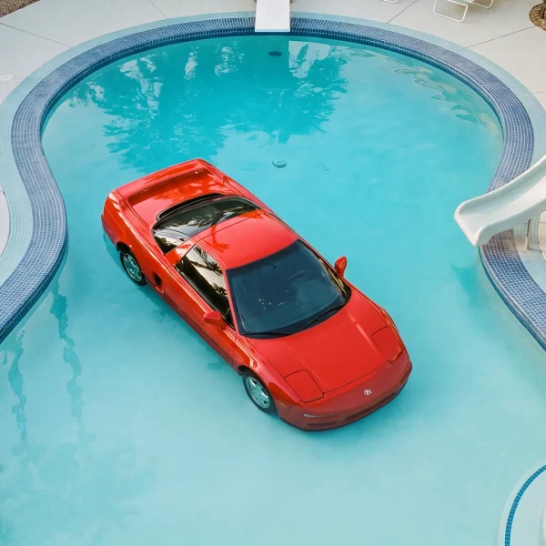 Zoomed in on a print of a red Acura NSX floating in a backyard pool.