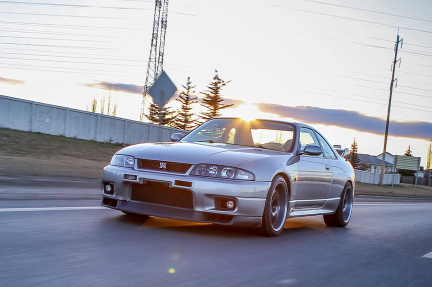 Silver R34 GTR driving on the street